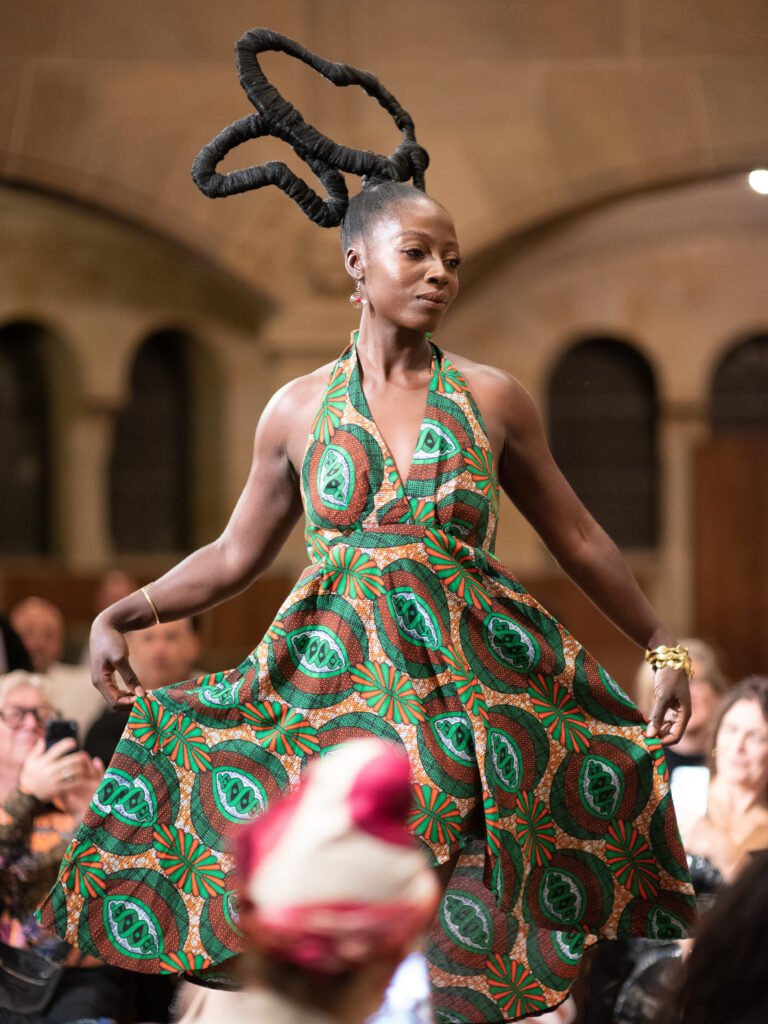 Model in a green print dress at the Black Essence Fashion Show