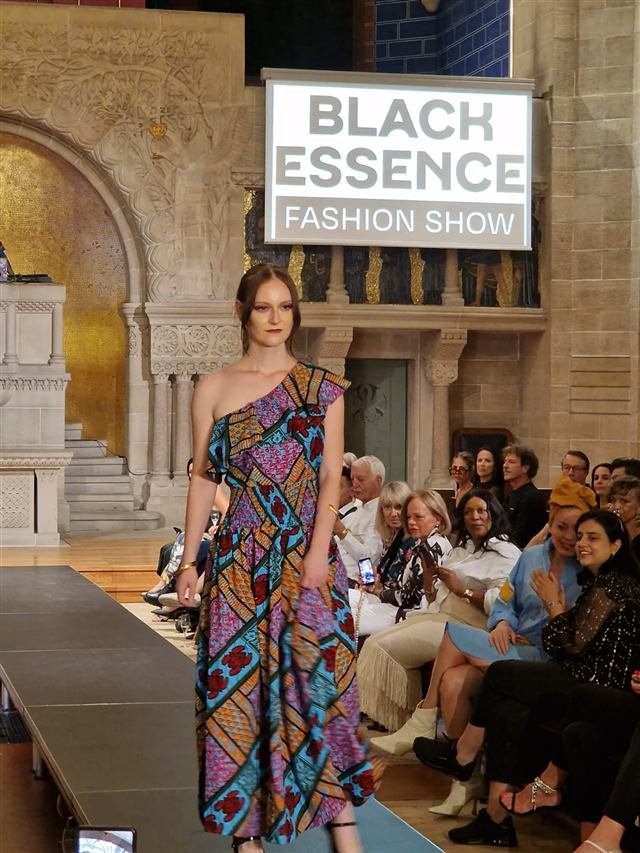 Model in a colourful patterned one-shoulder dress at the Black Essence Fashion Show in Basel